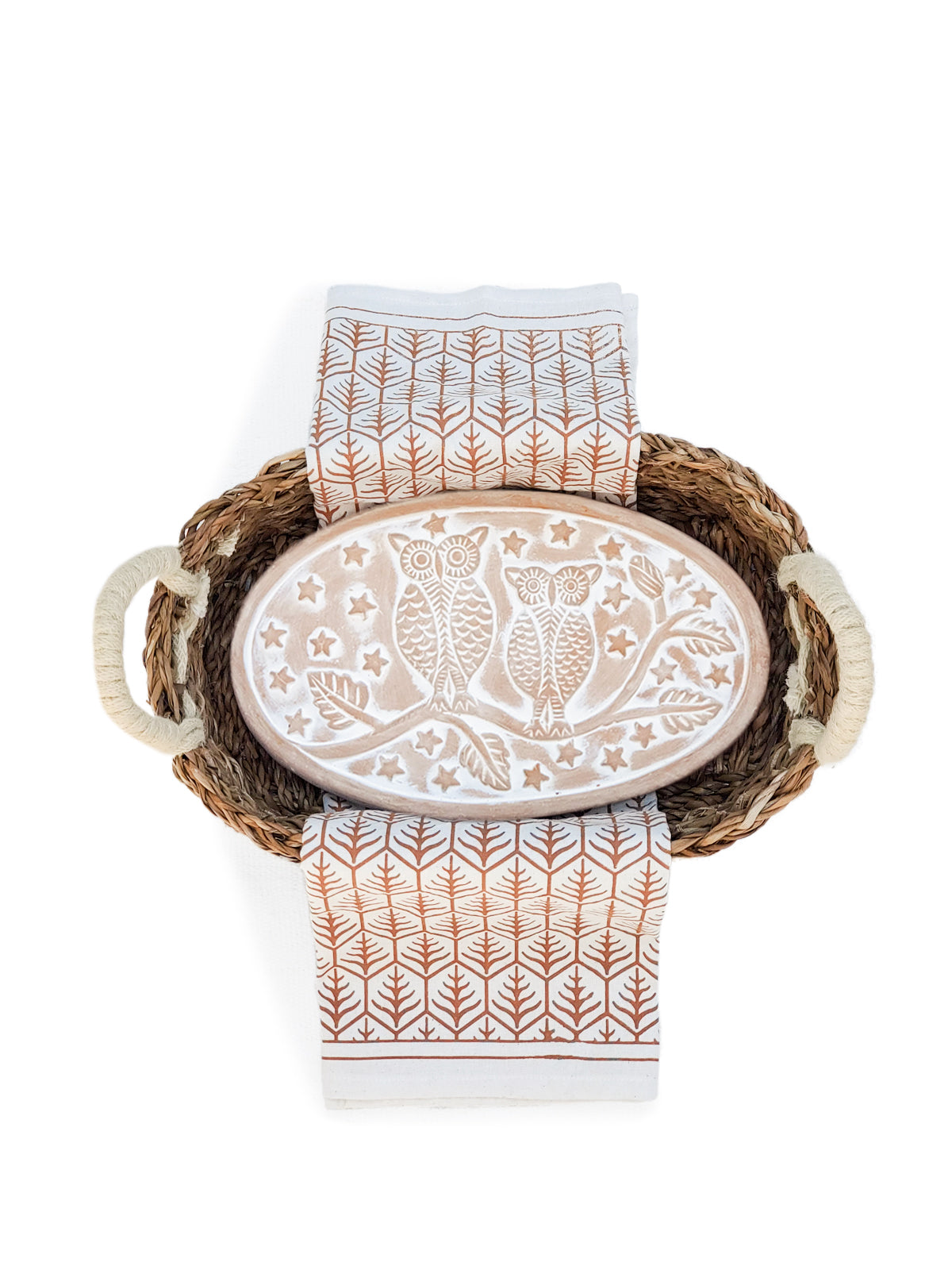 Oval owl bread warmer ceramic beige, in a woven basket with a brown leaf-pattern tea towel on Tampa Home & Garden Store