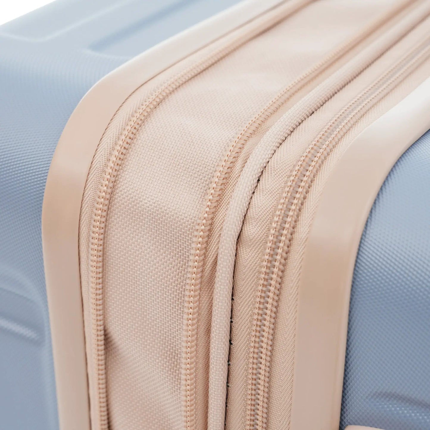 Expandable ABS hardside luggage closeup zipper in beige on blue background on Tampa Home & Garden Store