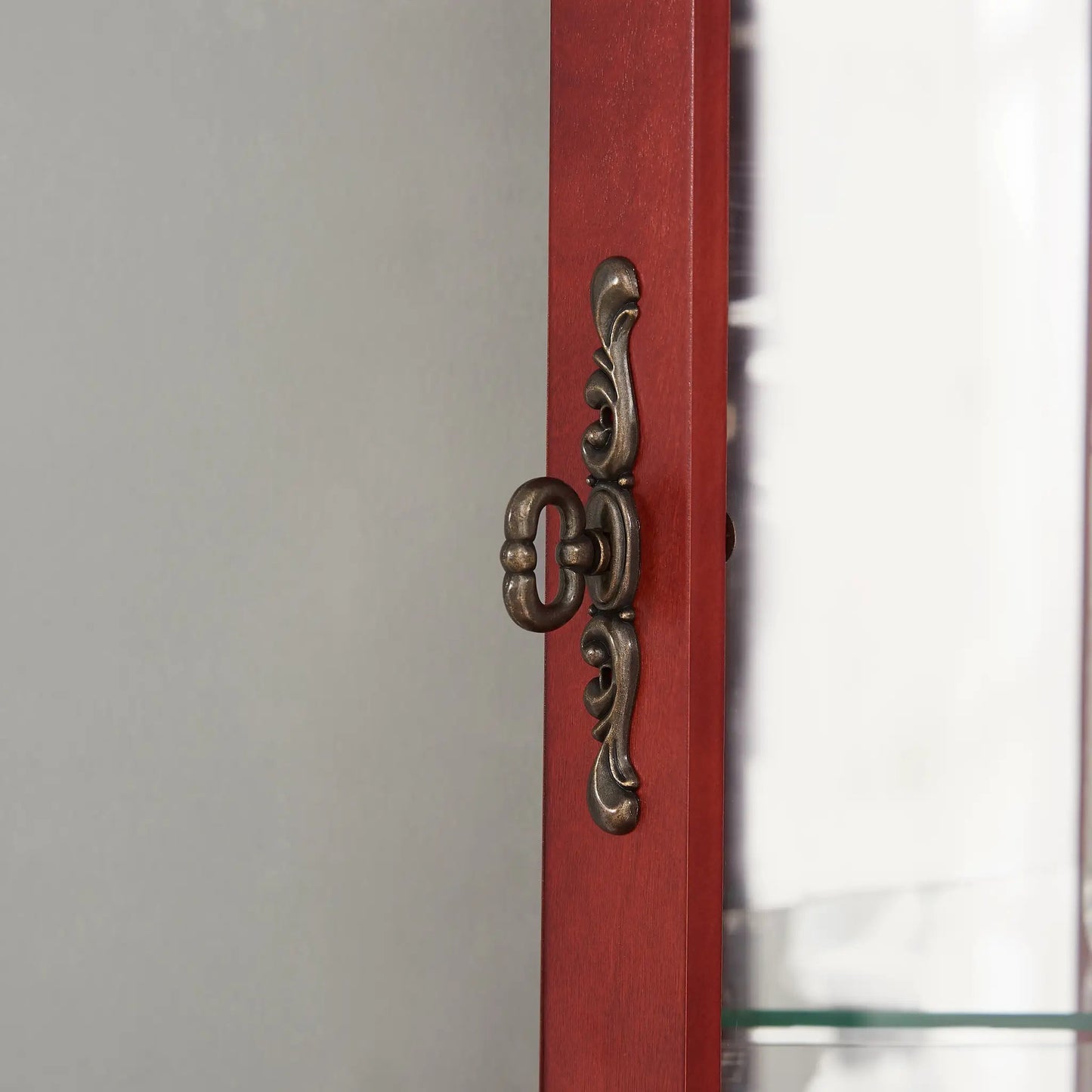 Corner Curio Cabinet with Lighted Glass Door red wood frame with ornate bronze hinge detail on Tampa Home & Garden Store