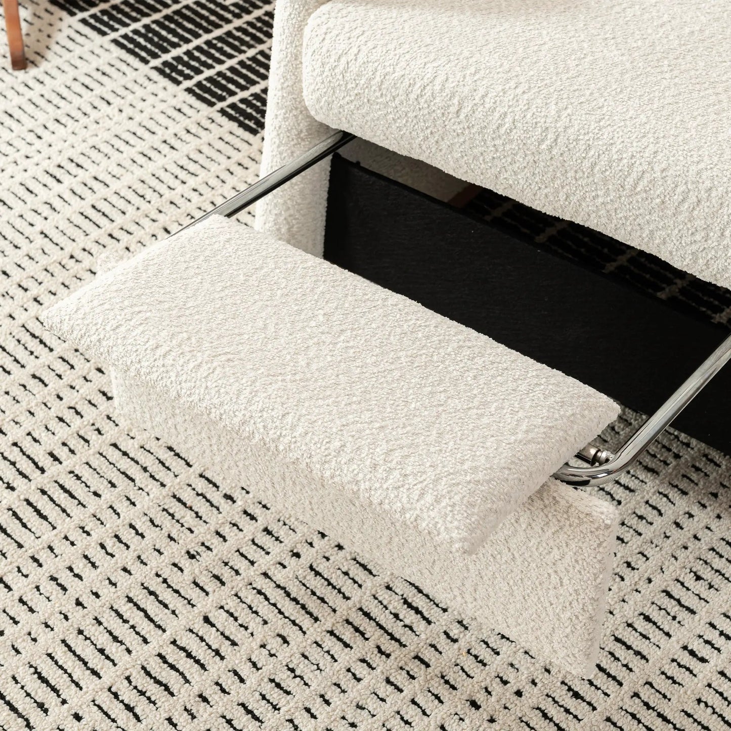 Accent rocking chair with footrest in beige boucle fabric and chrome frame on a black and white patterned rug on Tampa Home & Garden Store
