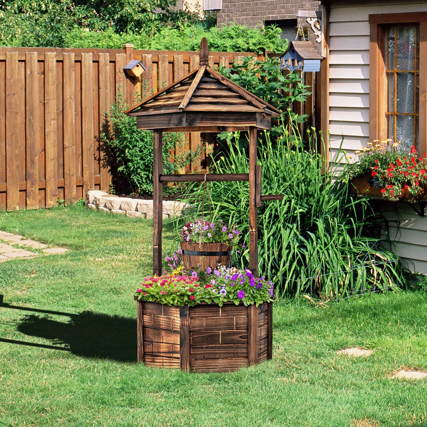 Rustic wooden wishing well with hanging bucket, weathered brown wood, flower-filled base planter on Tampa Home & Garden Store