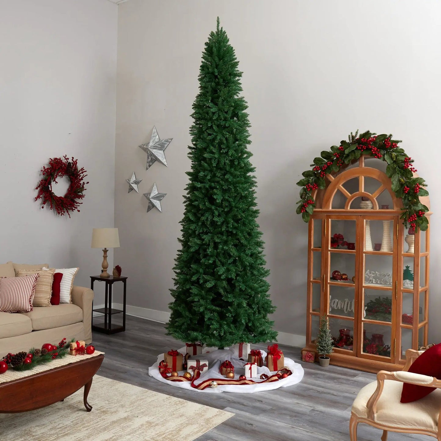 12 Foot Slim Green Mountain Pine Artificial Christmas Tree indoors with holiday decor on Tampa Home & Garden Store