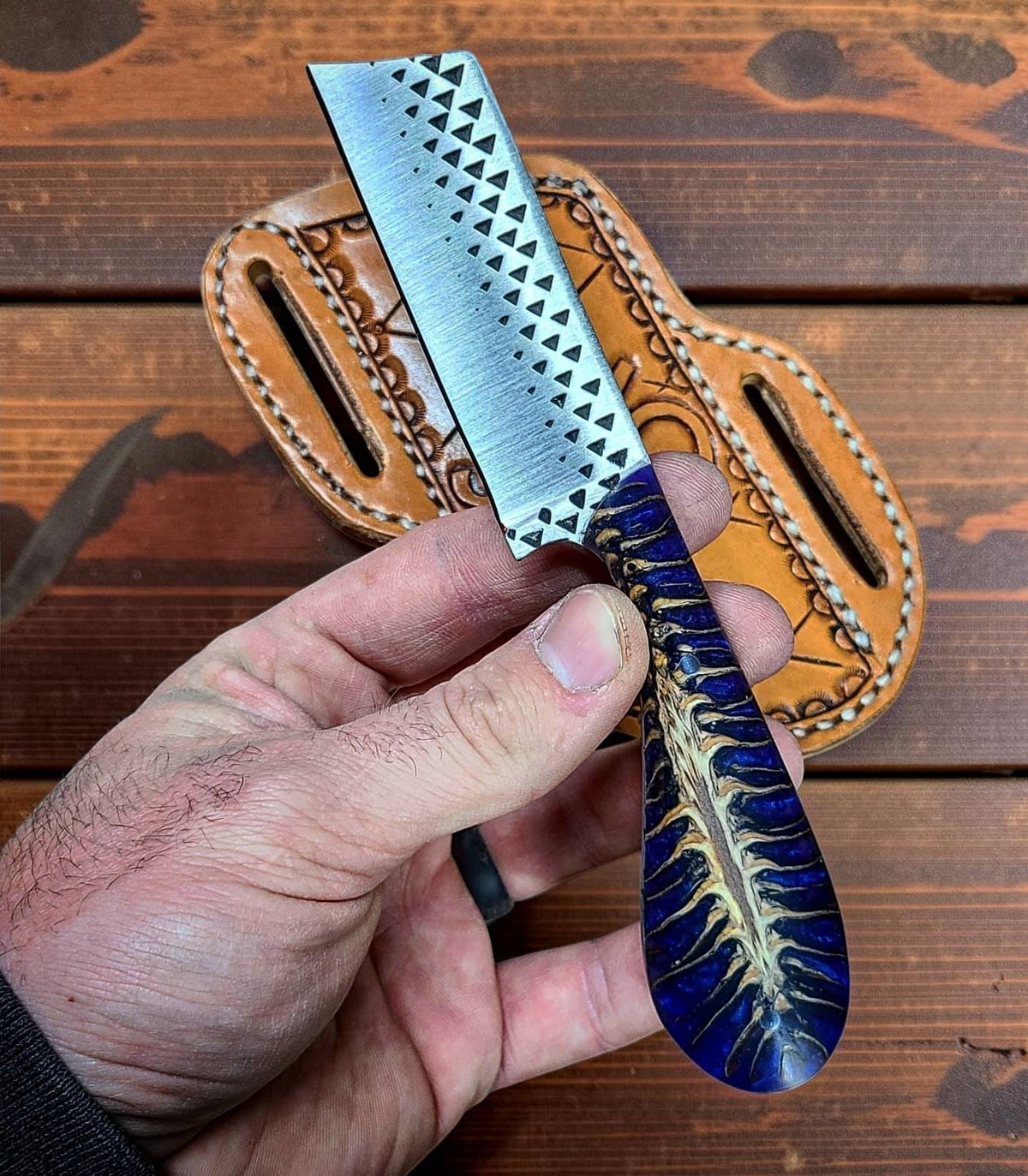 The Ponderosa custom bull cutter knife with blue epoxy pine cone resin handle and leather sheath on Tampa Home & Garden Store