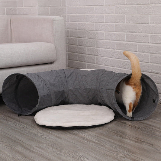 Cat tunnel in gray fabric with a white plush cushion; orange cat entering from the end on Tampa Home & Garden Store