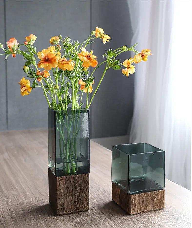 Glass vase set on wood bases; smoky green tall and small square vases with orange flowers on Tampa Home & Garden Store
