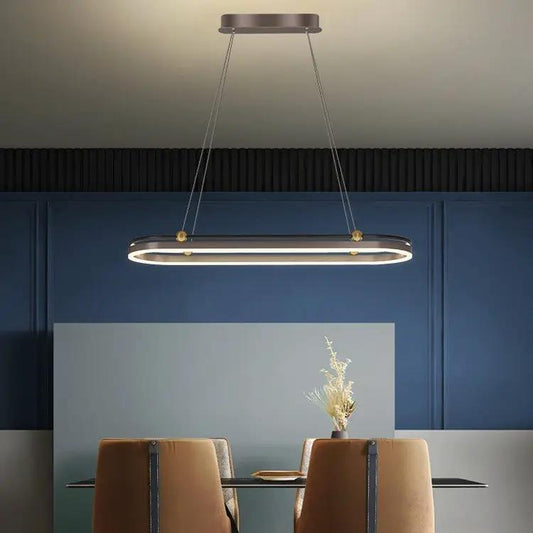 Modern dining room chandelier with elongated oval metallic frame, LED ring, gold accents on Tampa Home & Garden Store