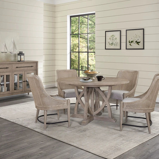 Round extendable dining table in sand with beige wicker chairs in a bright dining area on Tampa Home & Garden Store