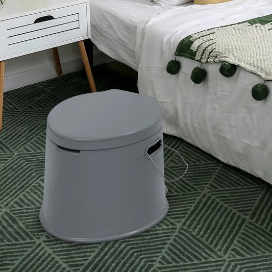 5L portable travel toilet in gray beside a bed in a modern bedroom with a round gray stool on Tampa Home & Garden Store