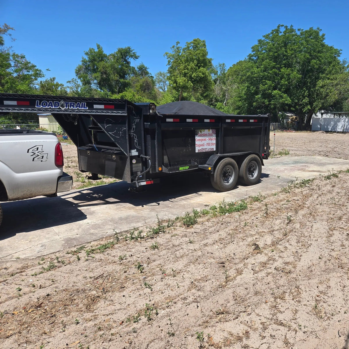 9 Cubic Yard premium landscaping topsoil truckload on Load Trail dump trailer delivery area on Tampa Home & Garden Store