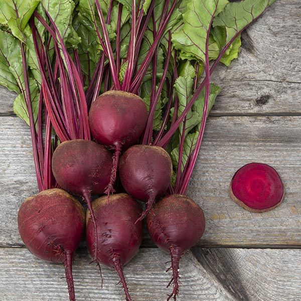 Red Ace F1 beet roots with purple stems on weathered wood; sliced beet shows red interior on Tampa Home & Garden Store