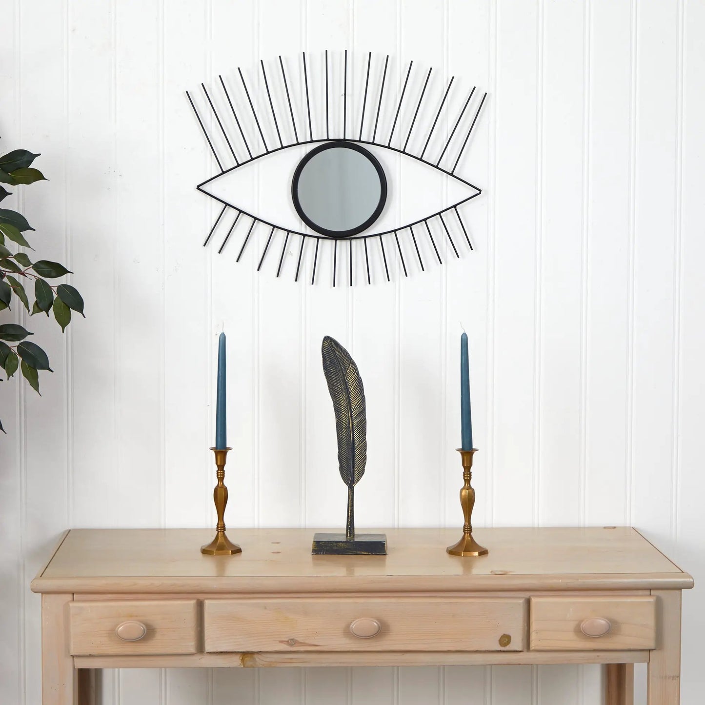 Eye-shaped wall mirror with black metal rays and a round center mirror on white wall on Tampa Home & Garden Store