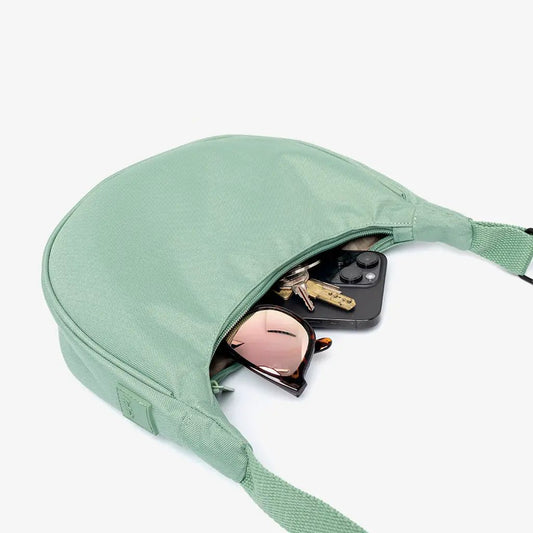 Lua Bag New Sage Compact Half Moon Crossbody by Lefrik USA with sunglasses and keys inside on Tampa Home & Garden Store