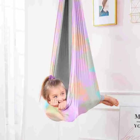 Children indoor outdoor sensory swing hammock in pastel rainbow fabric with a smiling child on Tampa Home & Garden Store
