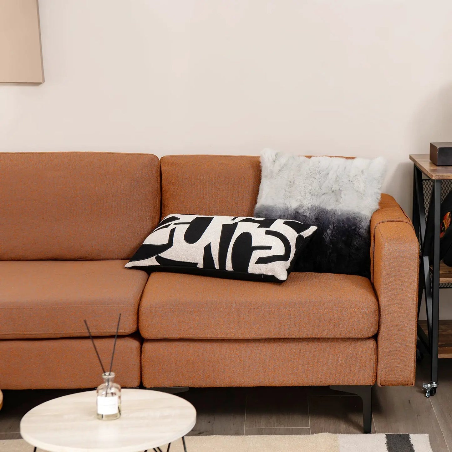 Modular orange L-shaped sectional sofa with USB ports and black and white geometric pillow on Tampa Home & Garden Store