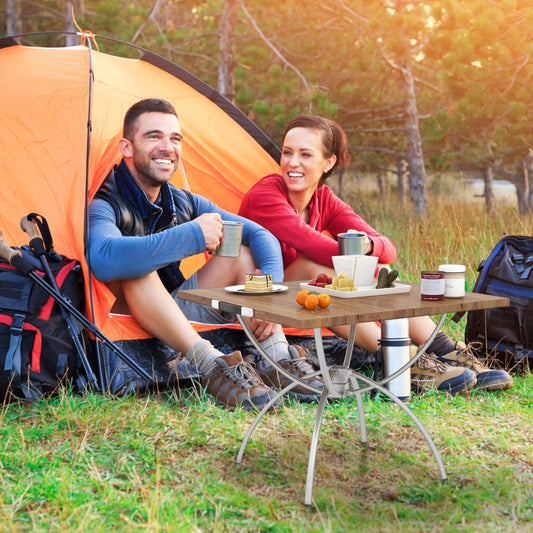 GemGear folding camping table with wood-grain top beside an orange tent at a campground on Tampa Home & Garden Store