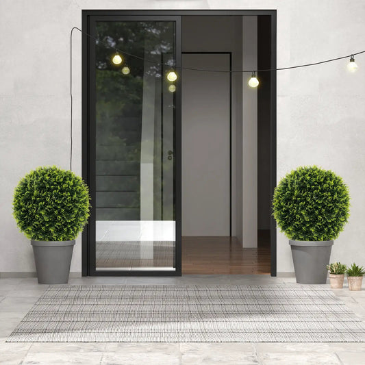 Two Pack 18 & 22 Inches Faux Decorative Balls in gray planters flanking a door with string lights on Tampa Home & Garden Store