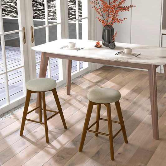 2 linen beige backless swivel bar stools with wood legs by white marble table in modern kitchen on Tampa Home & Garden Store