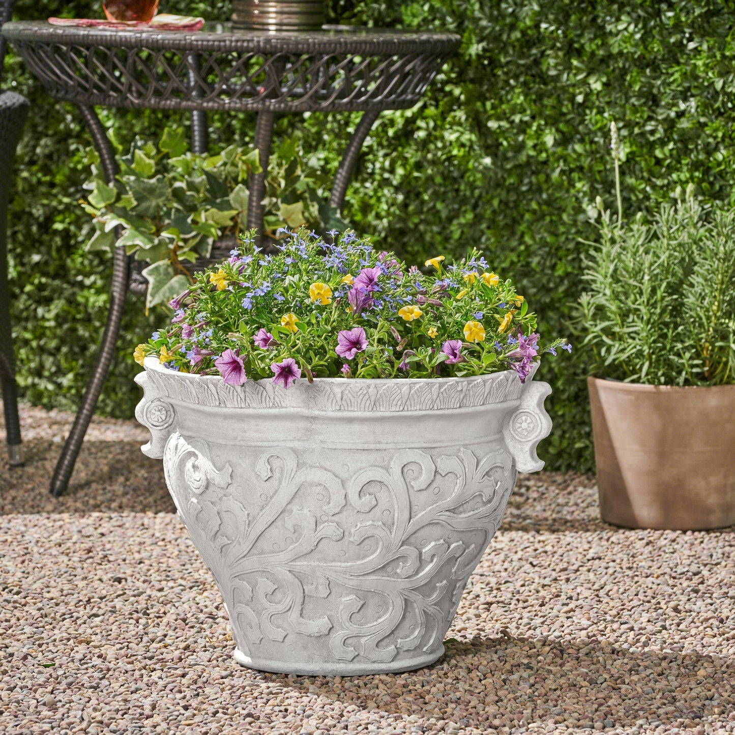Largo Planter by HouseOfZazla, gray stone planter with relief filled with petunias on Tampa Home & Garden Store