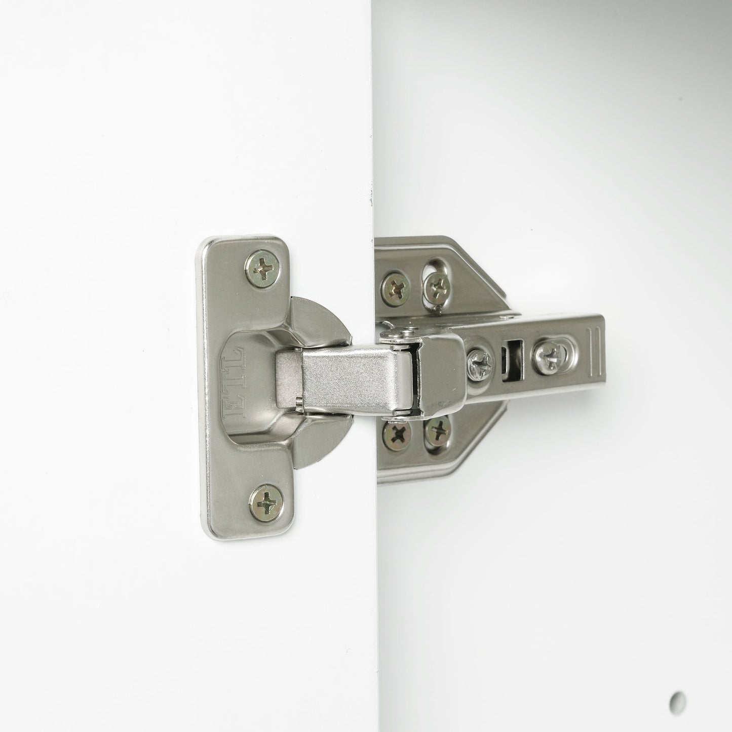 Bathroom vanity hinge closeup in brushed nickel on white cabinet with mounting screws on Tampa Home & Garden Store