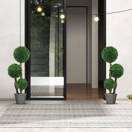 Two 36-inch boxwood topiary trees in pots flank a doorway with string lights on Tampa Home & Garden Store