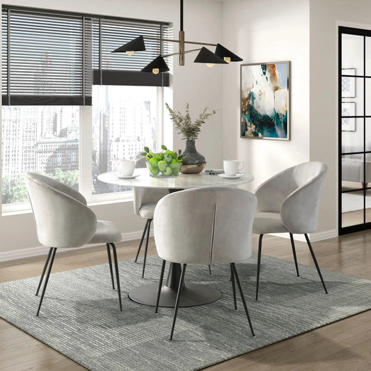 Beige velvet dining chairs with black metal legs around a white table in a modern dining room on Tampa Home & Garden Store