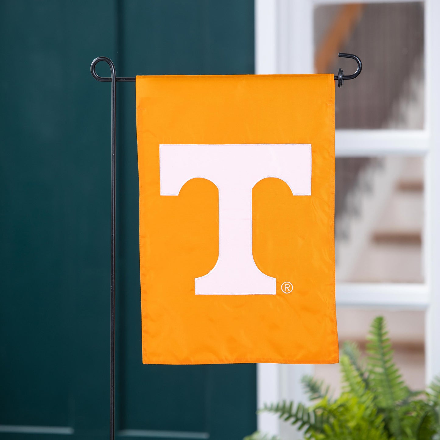 University of Tennessee applique garden flag orange with white UT emblem on black stand on Tampa Home & Garden Store