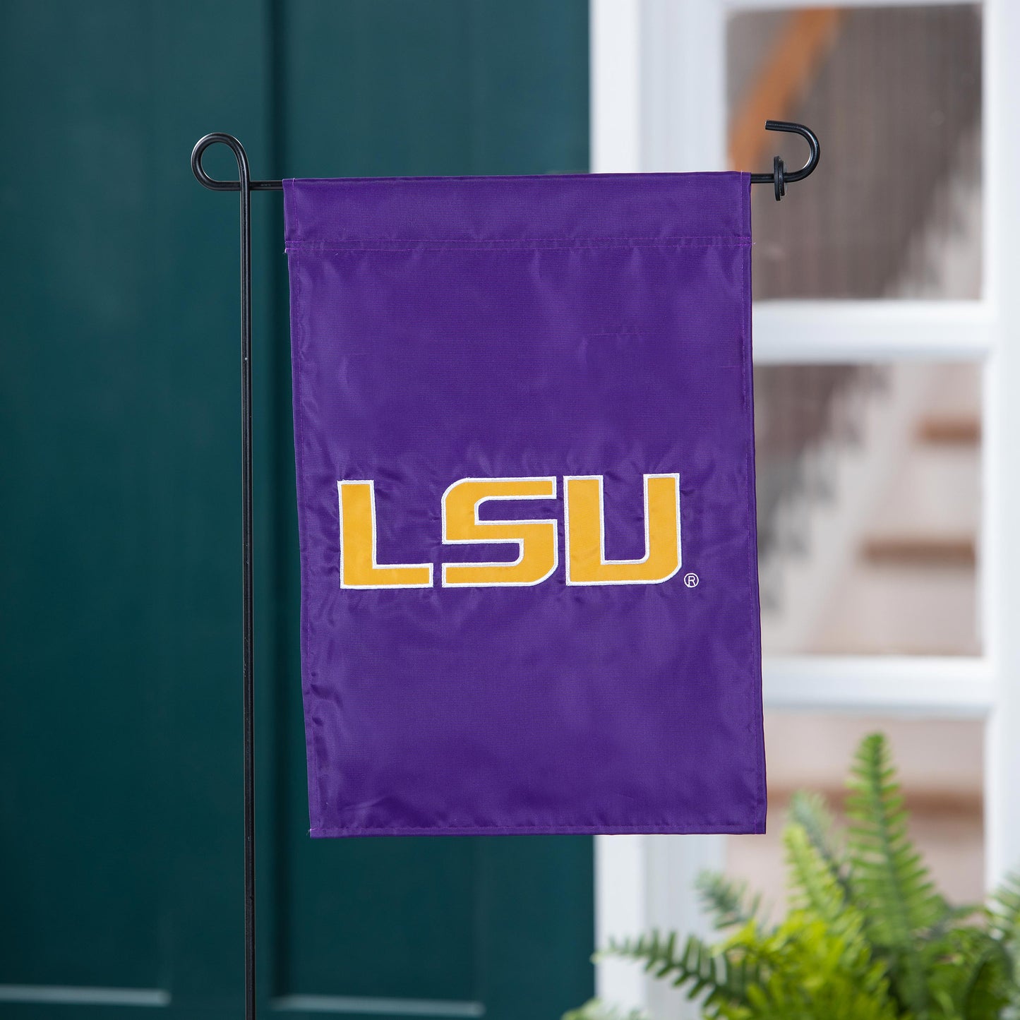 Louisiana State University applique garden flag in purple with yellow LSU letters on black stand on Tampa Home & Garden Store