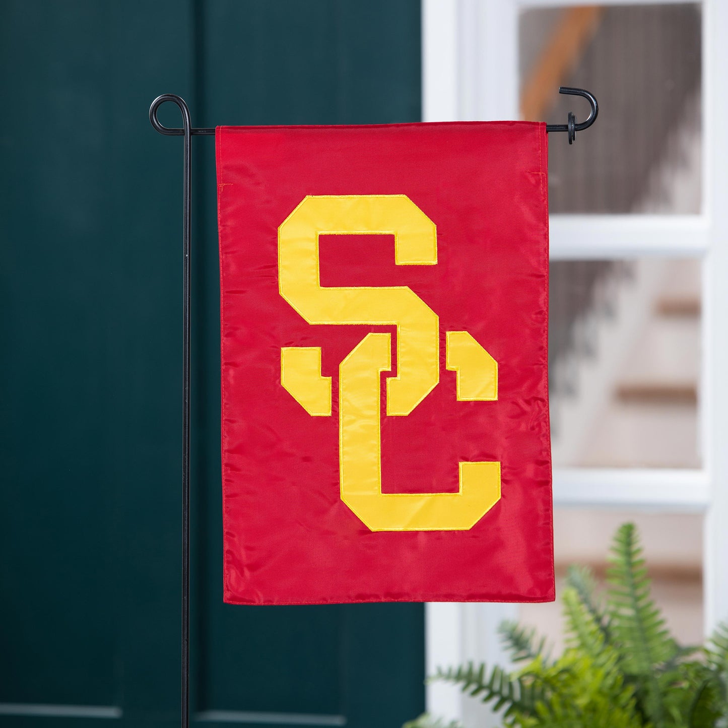 USC Applique Garden Flag by Evergreen Enterprises red with yellow letters on black metal stand on Tampa Home & Garden Store