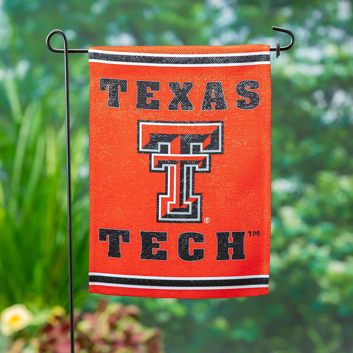 Embossed suede flag Texas Tech University in orange with bold black letters on metal stand on Tampa Home & Garden Store