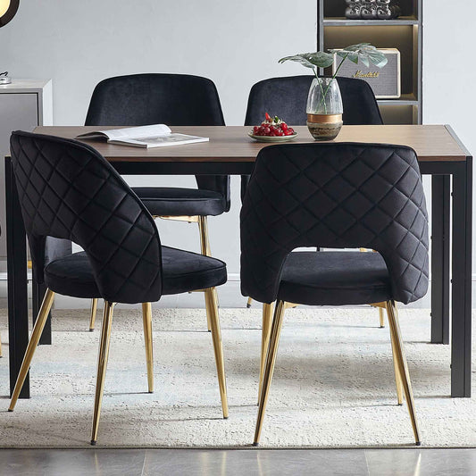 Black velvet dining chairs with gold metal legs, diamond quilting, set of 4 around a wood table on Tampa Home & Garden Store