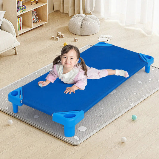 Blue plastic stackable daycare cot with a smiling child on it in a cozy playroom on Tampa Home & Garden Store