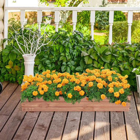Brown wooden decorative raised garden bed with orange marigolds on a deck beside a white railing on Tampa Home & Garden Store