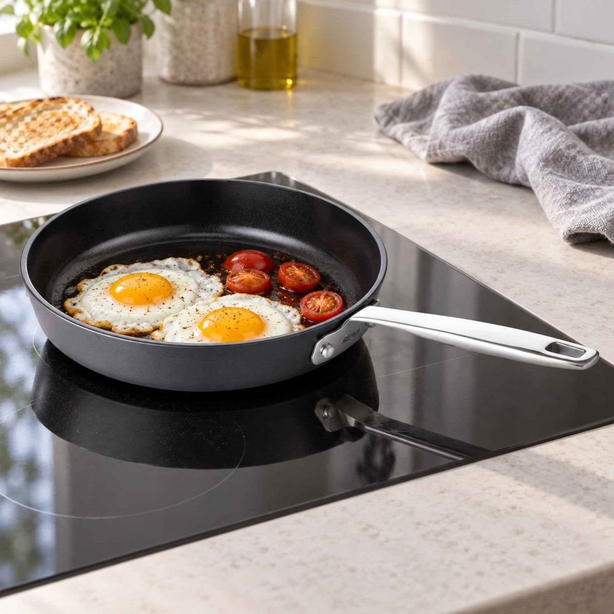 Alva Hybrid Cookware Set 7-Piece frying pan in black on stovetop with fried eggs and tomatoes on Tampa Home & Garden Store
