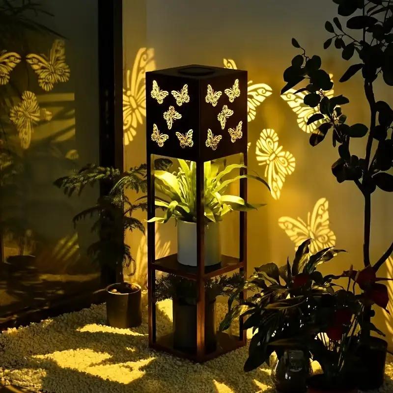 Solar garden lantern with butterfly cutouts in a black metal cube, warm LED glow on Tampa Home & Garden Store