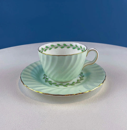 4-piece Minton porcelain teacup and saucer in pale green with gold trim and leaf motif on Tampa Home & Garden Store