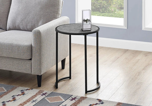 Round accent side table with textured gray top and black metal legs beside a gray sofa on Tampa Home & Garden Store