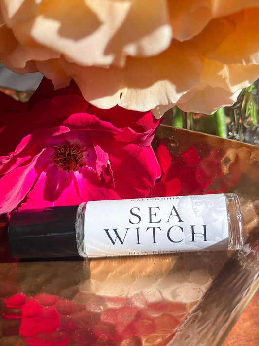 Sea Witch perfume oil bottle by In the Wick of Time, SEA WITCH label among pink blossoms on Tampa Home & Garden Store