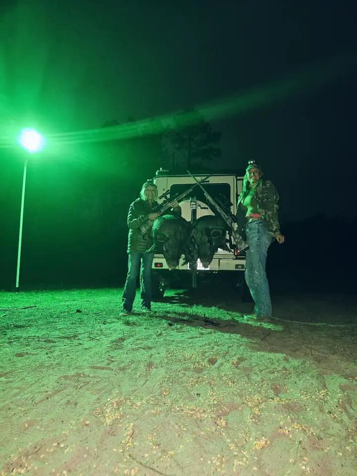 Green Langy Solar Lights hunting light, 15,000 lumens, outdoors at night with two hunters on Tampa Home & Garden Store