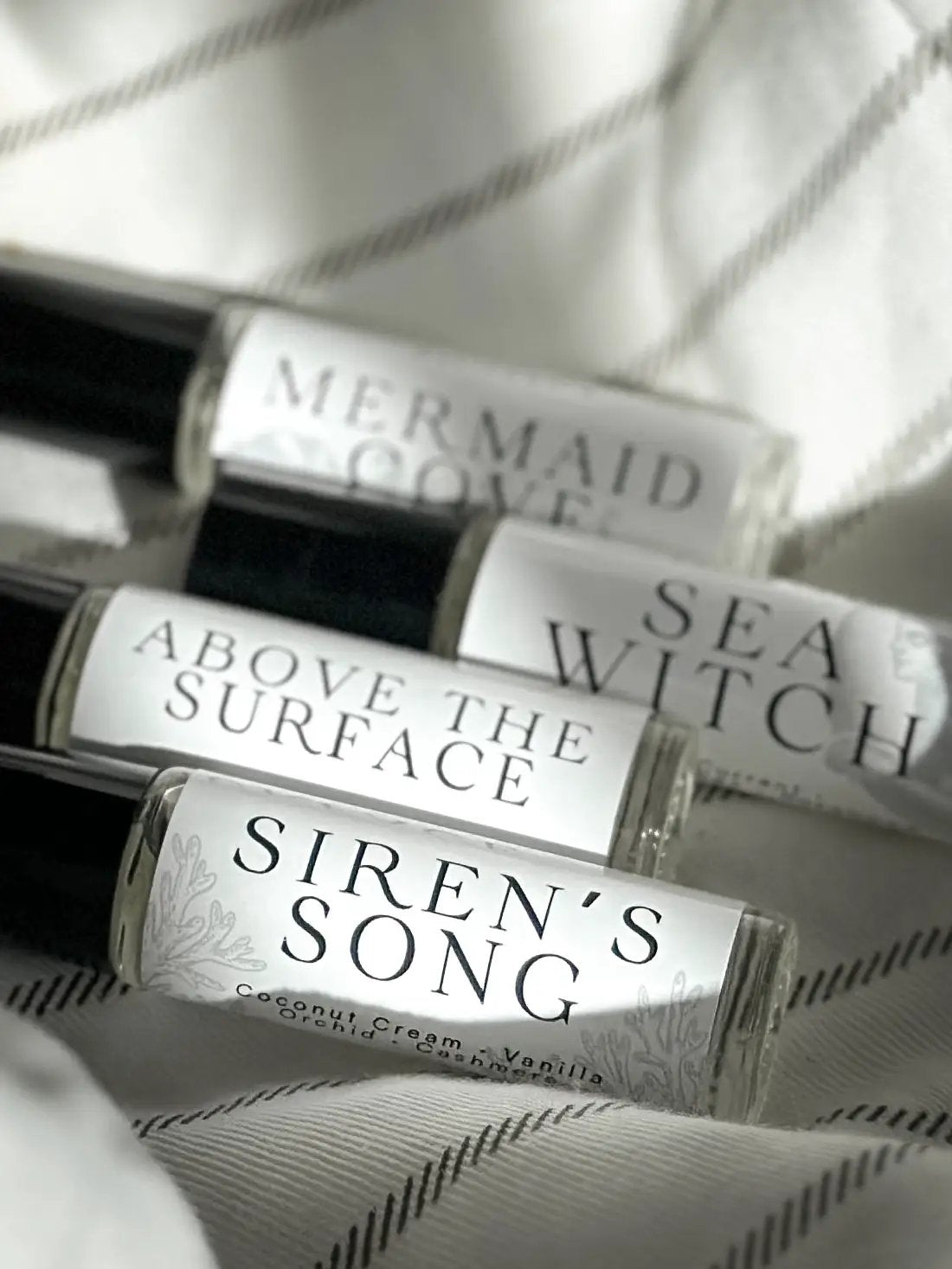 Sea Witch perfume oil set in clear glass rollers with white labels; Mermaid Cove, Siren’s Song on Tampa Home & Garden Store