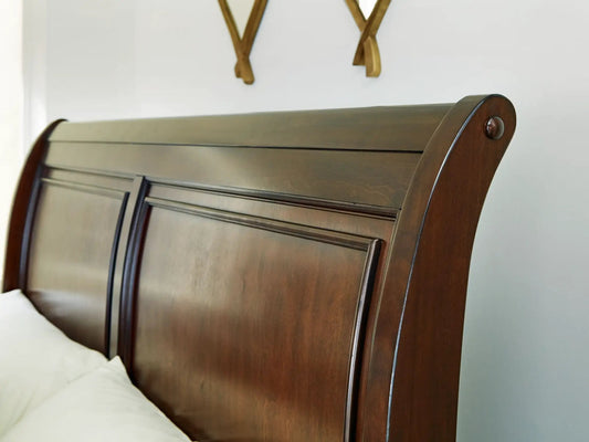 Trellington queen sleigh storage bed headboard in dark brown wood with paneled detailing on Tampa Home & Garden Store