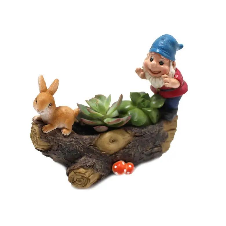 Dwarf rabbit flower pot decoration with blue-hatted garden elf on a bark log planter with succulents on Tampa Home & Garden Store
