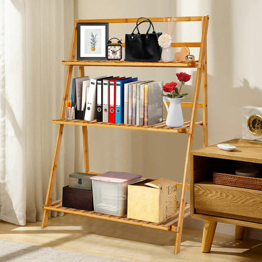Three-Tier Bamboo Foldable Plant Stand holding books and decor in natural finish on Tampa Home & Garden Store