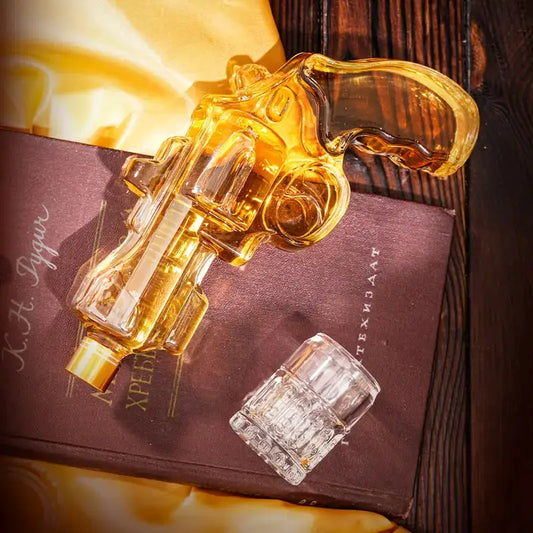 Revolver whiskey decanter set with amber glass revolver decanter and clear shot glass on a dark book background on Tampa Home & Garden Store