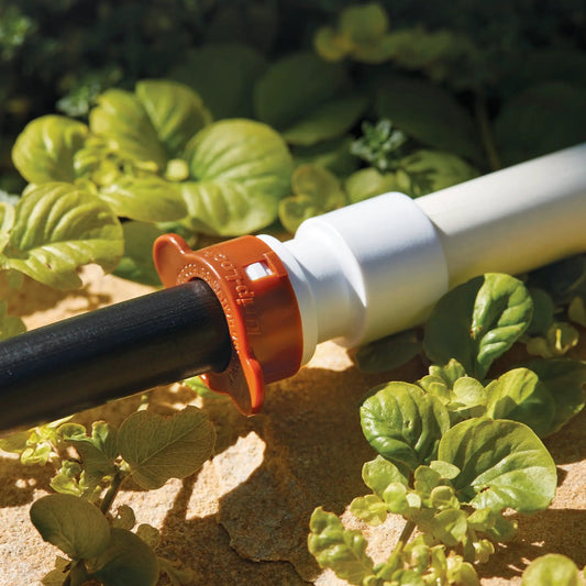 Drip-Lock Adapter PVC 3/4 to 1/2 in Orbit Irrigation with orange locking collar on white pipe on Tampa Home & Garden Store