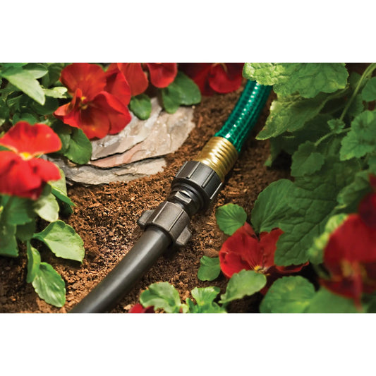Orbit Half Inch Universal Drip to Hose Faucet Adapter on green hose in garden bed with red blooms on Tampa Home & Garden Store