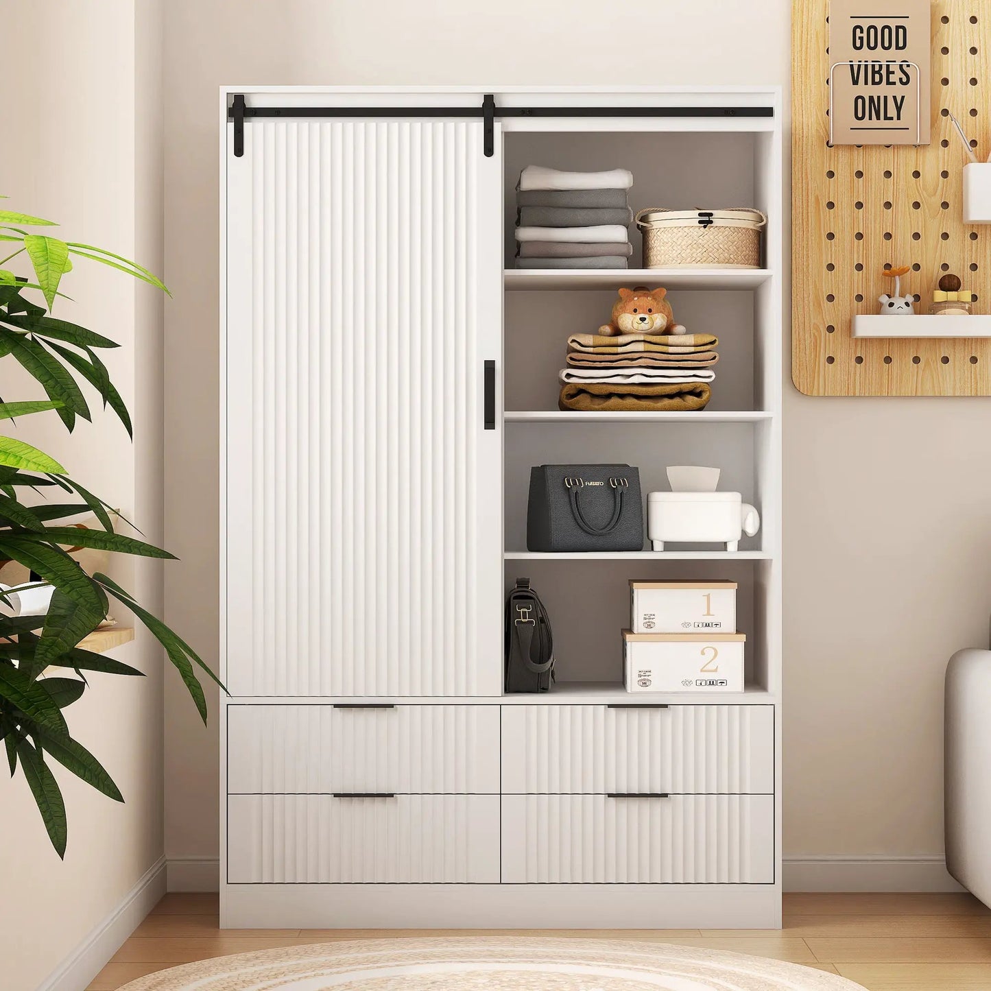 Tall white bedroom armoire with sliding barn doors, black hardware, folded textiles on Tampa Home & Garden Store