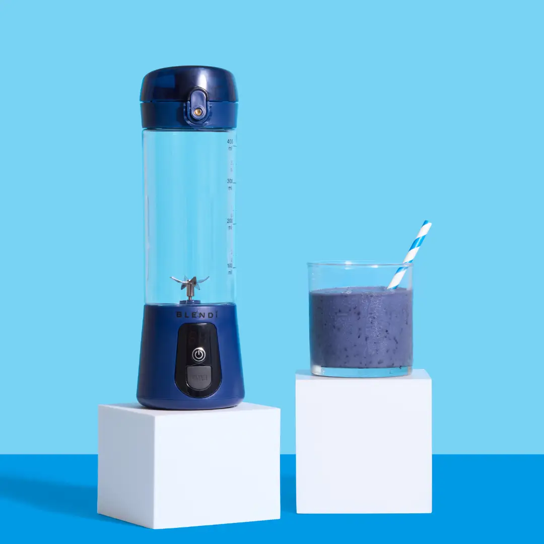 BLENDi Lite electric shaker with blue base and clear 17oz bottle beside a purple smoothie in a glass on Tampa Home & Garden Store