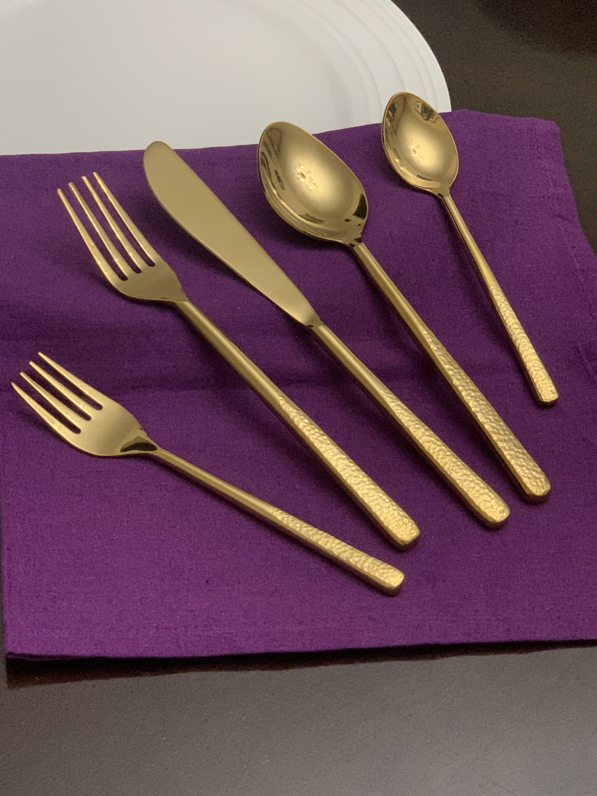 Vibhsa gold flatware 5-piece place setting with hammered handles on purple napkin on Tampa Home & Garden Store