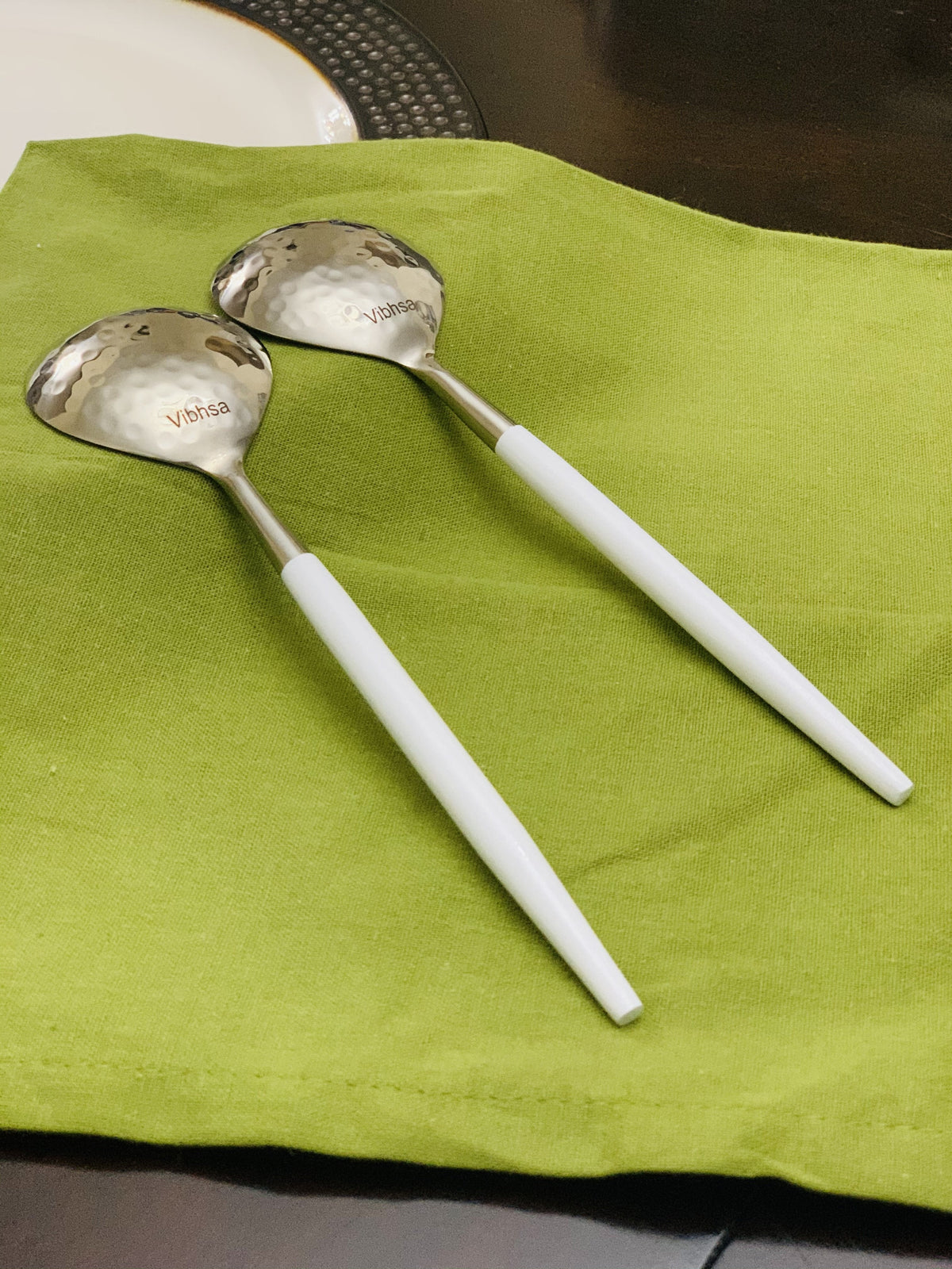 Vibhsa 6-PC tablespoon hammered-mouth serving set, 2 spoons with handles on green napkin on Tampa Home & Garden Store