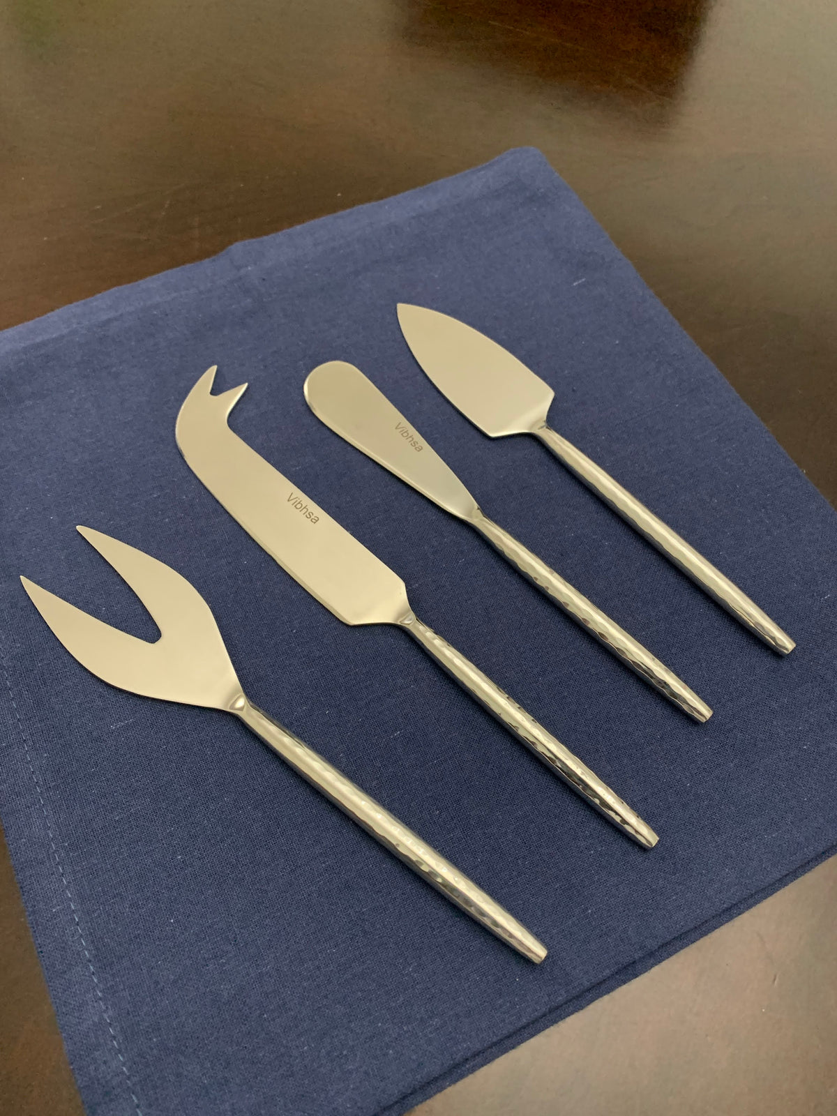 Vibhsa stainless steel cheese knives set of 4 on blue napkin on Tampa Home & Garden Store